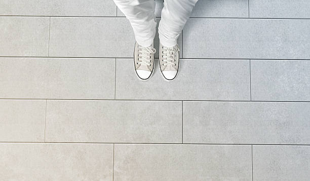 Person taking photo of his feet stand on concrete floor Person taking photo of his feet stand on concrete floor, isolated, top view, clipping path. Ground design mock up. Man wear gumshoes and watching down. Deck flooring mockup template. flat shoe photos stock pictures, royalty-free photos & images