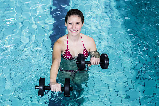 istock Smiling fit woman doing aqua aerobics 617752134