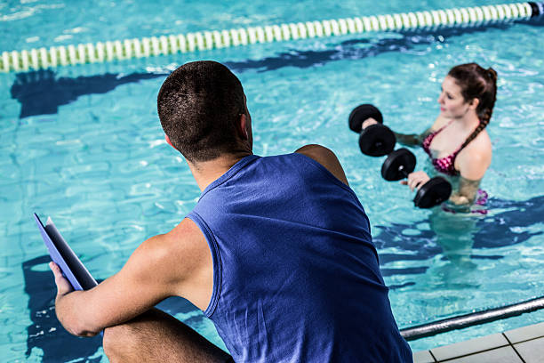 istock Smiling fit woman doing aqua aerobics 617752184