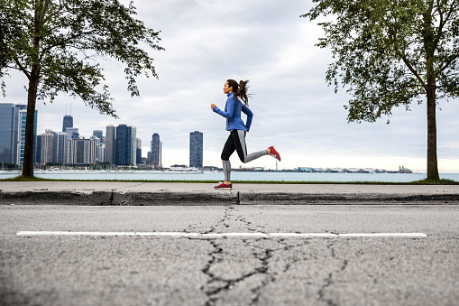 Woman working out in Chicago outdoor road runner in USA.