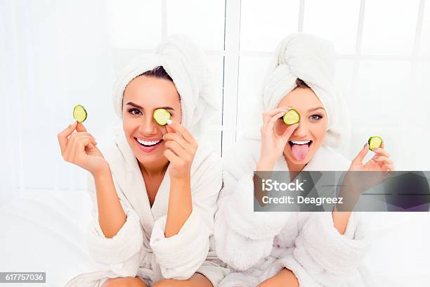 Comic Young Sisters After Shower Making Mask With Cucumber Stock Photo - Download Image Now