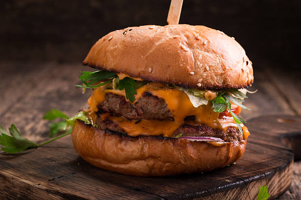 istock Tasty grilled burger with lettuce and mayonnaise , rustic wooden table 617759716