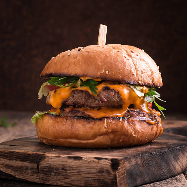 istock Tasty grilled burger with lettuce and mayonnaise , rustic wooden table 617759868