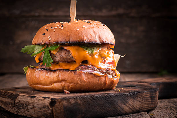 istock Tasty grilled burger with lettuce and mayonnaise , rustic wooden table 617759948
