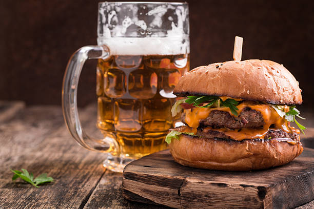 fresh hamburger with a beer on a wooden table. - cooked bread food cup imagens e fotografias de stock