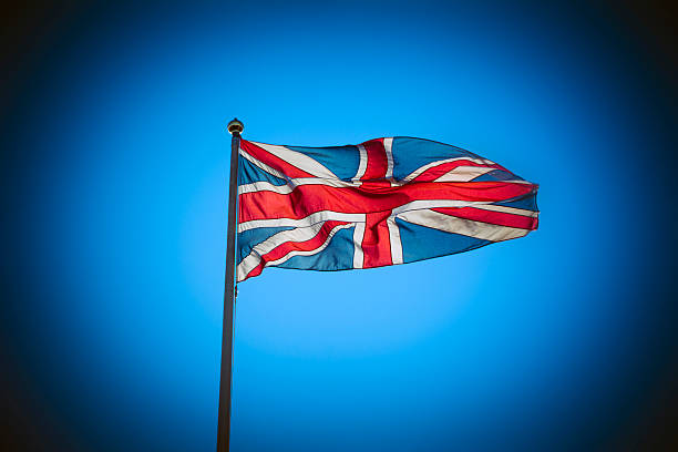 istock Great Britain Union Jack flag flying against blue sky 617761334