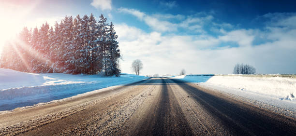istock Asphalt road in snowy winter on beautiful sunny day 617762048