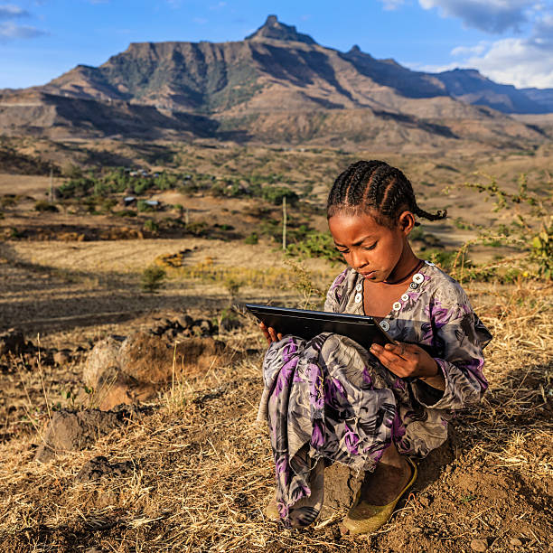 niña africana está usando tableta digital, áfrica oriental - village africa ethiopian culture ethiopia fotografías e imágenes de stock