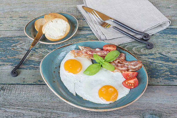 istock Fried eggs,  bacon, tomato, toast and butter 617765820