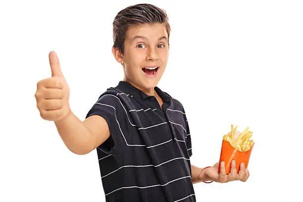 Photo of Boy giving a thumb up and holding bag of fries