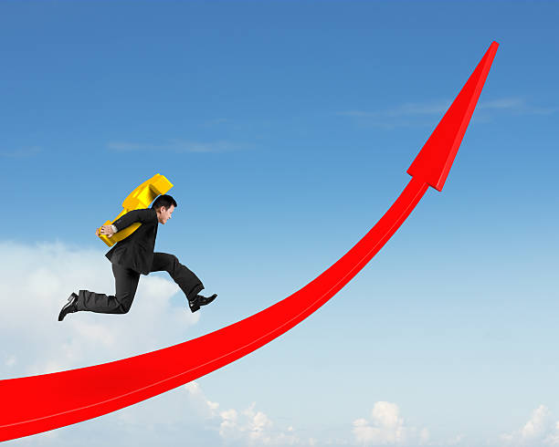 istock Man carrying dollar sign running on red arrow up graph 617767588