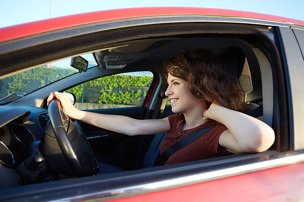 istock young woman driving a new car 617770232