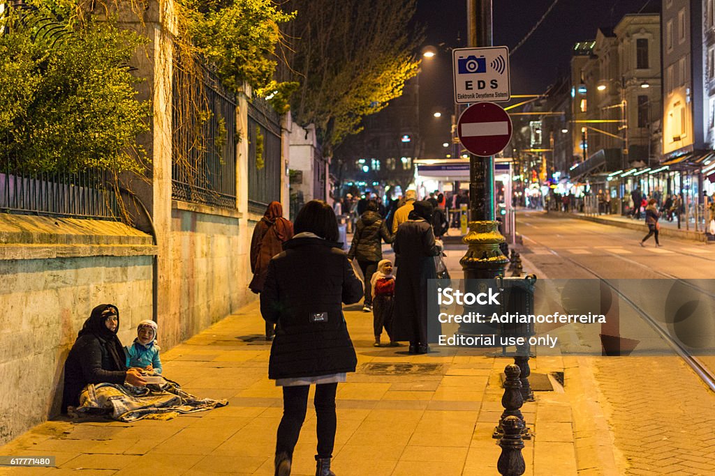 Sultanahmet area during night, Istanbul, Turkey Istanbul, Turkey - April 15, 2015 - Sultanahmet during night with tourists, locals and a refugee woman with her child Adult Stock Photo