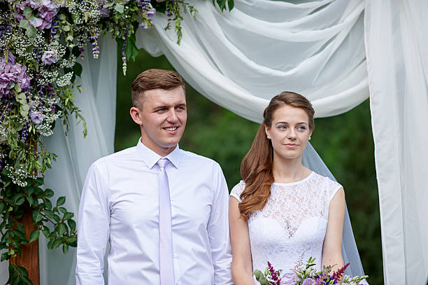 istock bride and groom at a wedding ceremony under the arch 617773368