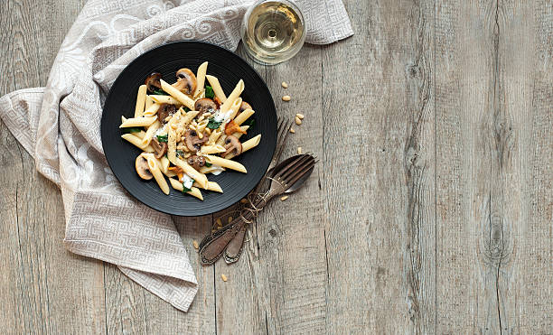 Pasta with mushrooms on rustic wooden table stock photo