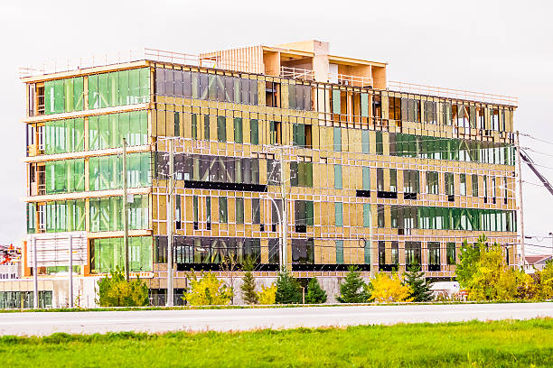 Complexe Synergia, LEED Saint-Hyacinthe, Сanada - October 24, 2016: SYNERGIA COMPLEX Built at the corner of Casavant Boulevard and East Johnson Street, Saint-Hyacinthe, Quebec. The tower at prestigious offices will be built according to strict standards of sustainable development and seeks LEED certification. The building with modern architecture present an apparent wood structure as well as imposing fenestration, allowing access to natural light and great views. saint hyacinthe photos stock pictures, royalty-free photos & images