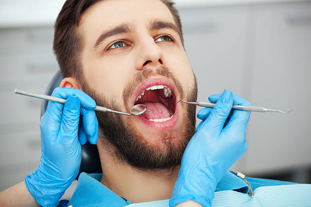 joven que consigue sus dientes revisados por un dentista. - dental hygiene fotografías e imágenes de stock