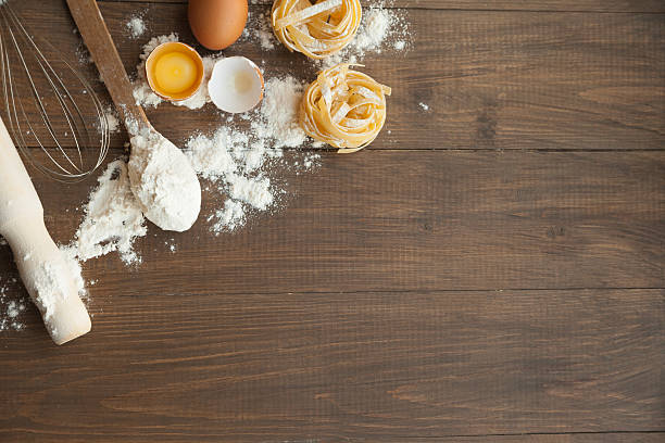 istock Cuisine composition with fettuccine cracked eggs,kitchenware, flour. 617775930