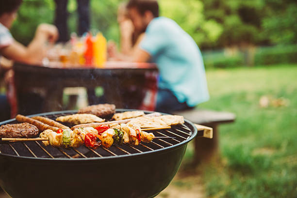 Time for barbecue Friends making barbecue and having lunch in the nature. barbecue grill stock pictures, royalty-free photos & images