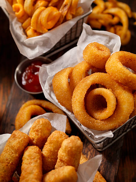 Baskets of Onion Rings, Curly Fries and Cheese Sticks Basket of Onion Rings-Photographed on Hasselblad H3D2-39mb Camera fried onion rings stock pictures, royalty-free photos & images