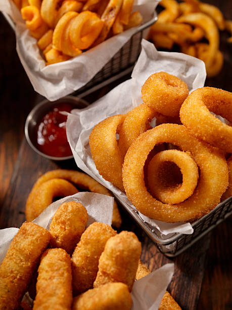 Baskets of Onion Rings, Curly Fries and Cheese Sticks Basket of Onion Rings-Photographed on Hasselblad H3D2-39mb Camera deep fry stock pictures, royalty-free photos & images
