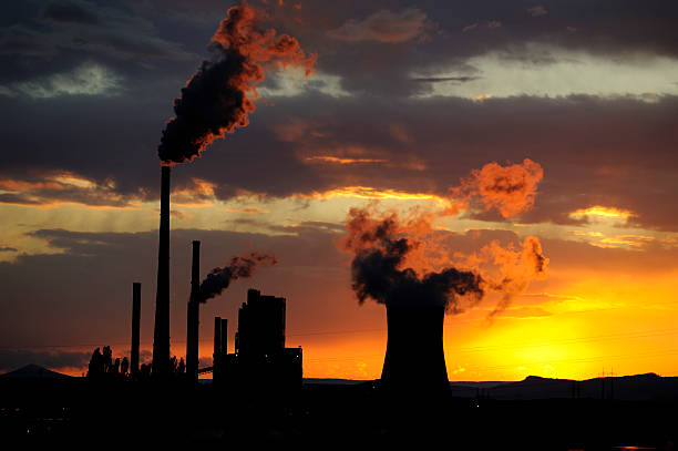 istock Coal power station with smoking chimneys in sunset 617863308