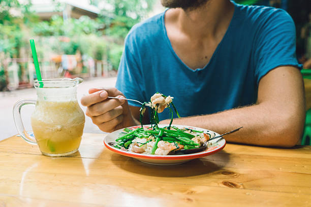 Young Caucasian man eating   in cafe in Bangkok, Thailand 