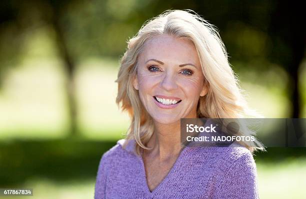 Portrait Of A Mature Woman Smiling At The Camera At The Park Stock Photo - Download Image Now