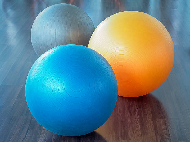 balles en caoutchouc de fitness sur parquet - yoga ball photos et images de collection