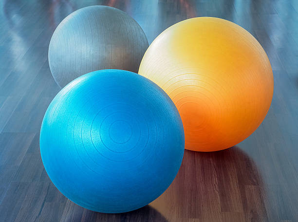 palle di gomma fitness sul pavimento in parquet - yoga ball foto e immagini stock