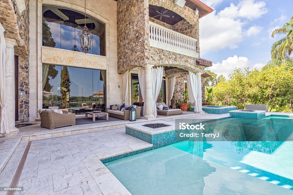 Outdoor Living with a Beautiful View Beautifully designed outdoor living area at an estate home with a view overlooking a lake. Swimming Pool Stock Photo