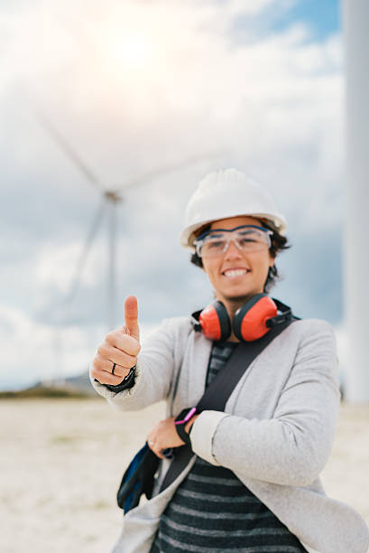 istock smiling engineer woman doing thumbs up sign with safety helmet 617870694