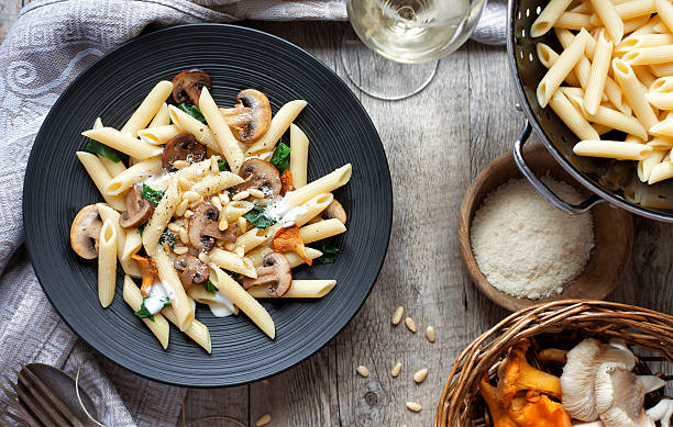 Pasta with mushrooms on rustic tabletop. stock photo