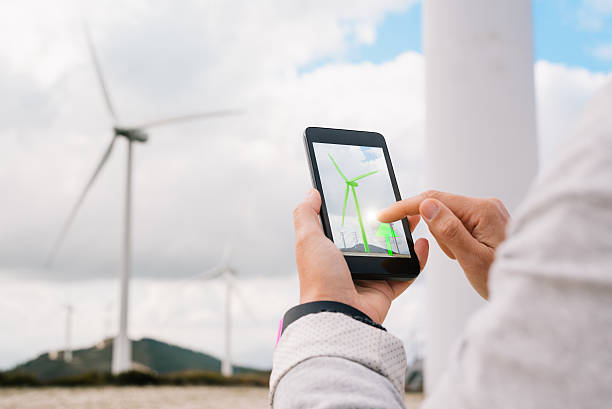 istock Engineer managing wind power energy production app touching phone screen 617871976