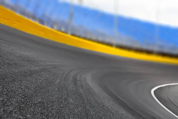 Empty race track at a motor speedway for motorsports at turn 1. Shallow dof.