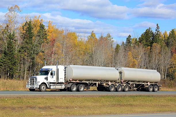 istock Tanker truck on a highway, trees in background. 617873278
