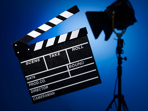 Film slate with spotlight in front of blue-box background