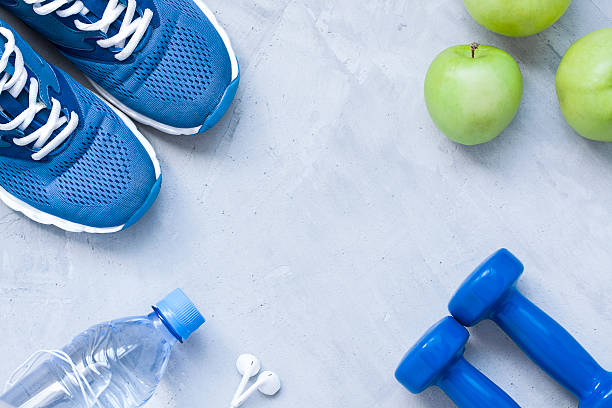 フラットレイスポーツシューズ、ダンベル、イヤホン、リンゴ、ボトル入り飲料水 - exercise equipment exercising dieting sport ストックフォトと画像