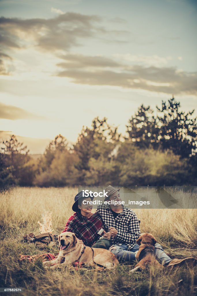 Couple drinking tea in front of bonfire Couple drinking tea by bonfire Couple - Relationship Stock Photo