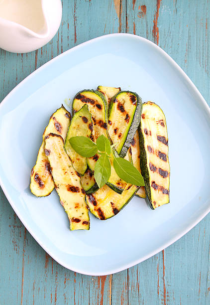 istock Zucchini grilled on a blue plate with basil 617886460