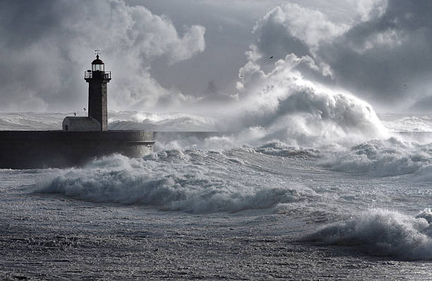 Storm waves over the Lighthouse Storm waves over the Lighthouse, Portugal - enhanced sky sea storm stock pictures, royalty-free photos & images