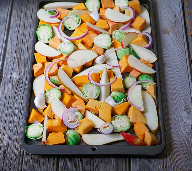 istock Roasted cut vegetables and fruit on a baking sheet. 617889818