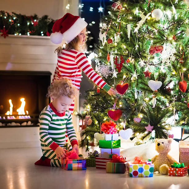 istock Kids in pajamas under decorate Christmas tree 617891074
