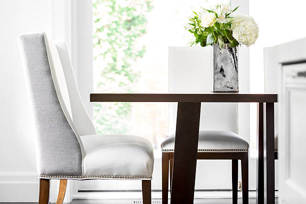 Detail of dinning table with white leather upholstered chairs