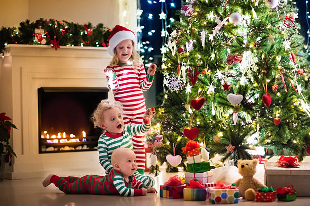 istock Happy little kids in pajamas under Christmas tree 617891786