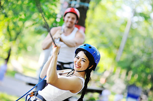 istock couple having fun in the park on a rope way 617892860