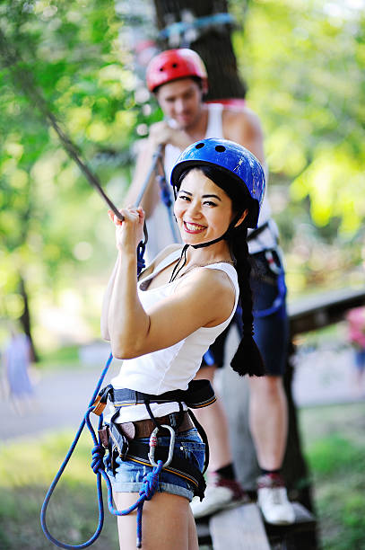 istock boy and girl climbing on rope road 617892874