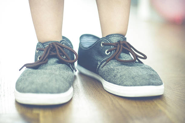 istock Child feet in father's shoes 617894852