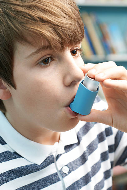 istock Boy Using Inhaler To Treat Asthma Attack 617896330