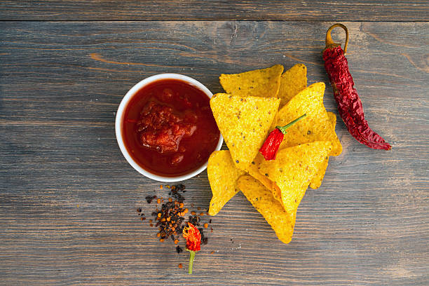 istock Hot chili salsa sauce with nachos chips, dried chili pods 617896876